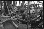 Pig festival, stake-planting, Tuguma: man bespells stakes, cordyline and other materials for ritual