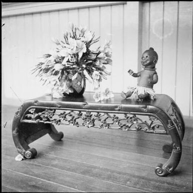 Bowl of frangipanni and a doll in native costume on a Chinese table, Rabaul, New Guinea, ca. 1936 / Sarah Chinnery