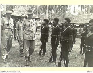 AITAPE, NEW GUINEA. 1945-03-23. LORD WAKEHURST, KCMG, GOVERNOR OF NEW SOUTH WALES (3), ACCOMPANIED BY WARRANT OFFICER I MACKENZIE (1) INSPECTING A GUARD OF HONOUR OF THE ROYAL PAPUAN CONSTABULARY ..