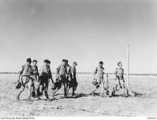 FORBES, AUSTRALIA. 1943-02. "GUINEA PIGS" TAKING PART IN A GAS SHELL EXPERIMENT RETURNING FROM THE CONTAMINATED AREA TO PLACE THEIR CONTAMINATED CLOTHING IN BINS FOR DECONTAMINATION