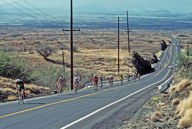 Participants bike uphill during the 112-mile bicycle race, part of the 1987 Ironman Competition