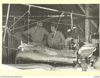 LAE, NEW GUINEA. 1945-03-27. LADY WAKEHURST (2), ACCOMPANIED BY SX1471 MAJOR N.P. WILSON, OFFICER- IN- CHARGE OF THE WARD (1) SPEAKS WITH QX51942 PRIVATE L.J. HUNTER, DURING HER VISIT TO BATTLE ..