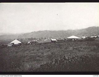 WAU, NEW GUINEA. 1942-08. WAU SEEN FROM THE STEPS OF A HOUSE ON THE EDGE OF KORANGA CUTTING SHORTLY BEFORE ITS DESTRUCTION. SETTLERS HOMES ARE AMONG THE KUNAI GRASS, THE MAIN TOWNSHIP IN THE ..