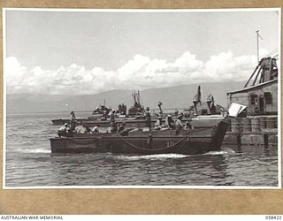 LAE, NEW GUINEA, 1943-10-13. THE FINSCHHAFEN BARGE MOVING INTO THE DOCKS