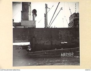 BORAM, NEW GUINEA, 1945-08-06. AN AUSTRALIAN LANDING CRAFT WORKING WITH HQ COMMAND, AUSTRALIAN ARMY SERVICE CORPS, 6 DIVISION, UNLOADING SUPPLIES FROM THE OCEAN FREIGHTER FOR TRANSPORT TO THE SHORE