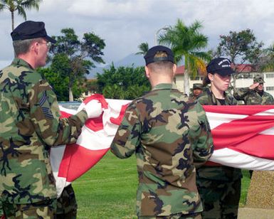 US Air Force CHIEF MASTER Sergeant Jeffrey Herman, leads the Hickam AFB, Hawaii Honor Guard Team as they fold an American Flag during a retreat Ceremony