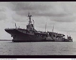 MANUS ISLAND, NEW GUINEA. 1949-09. PORT BOW VIEW OF THE AIRCRAFT CARRIER HMAS SYDNEY (III) AT ANCHOR. NOTE THE TYPE 960 AIR SEARCH RADAR AT THE MASTHEAD, TYPE 293Q AIR/SURFACE SEARCH RADAR JUST ..