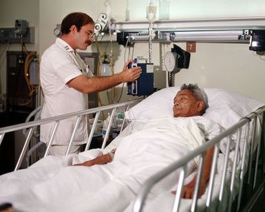 STAFF Sergeant Robert Carter, a physical therapy specialist, assists Arthur Knapp with his therapy at Tripler Army Medical Center