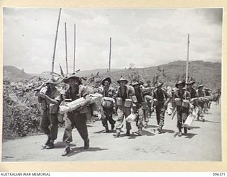RABAUL, NEW BRITAIN, 1945-09-10. TROOPS OF 13 FIELD COMPANY, ROYAL AUSTRALIAN ENGINEERS, WITH THEIR GEAR, MARCHING ALONG THE ROAD FROM MALAGUNA TOWARDS RABAUL TOWNSHIP. THEY ARE PART OF THE FORCE ..