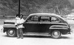 Samoan American man and child beside automobile