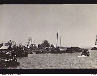LAE, NEW GUINEA. 1943-10-12. VIEW OF THE WATERFRONT SHOWING A PILE-DRIVER IN OPERATION ON THE EXTREME RIGHT