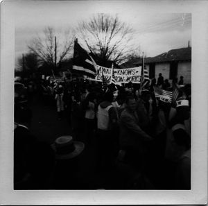 Marchers on the streets of Montgomery carrying a banner reading 'Hawaii knows integration works'