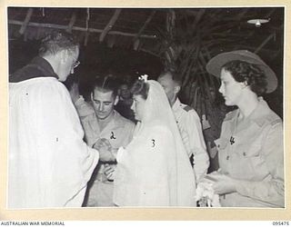 LAE AREA, NEW GUINEA, 1945-08-25. SERGEANT G.H. HODGES, 48 OPERATIONAL BASE UNIT ROYAL AUSTRALIAN AIR FORCE WITH HIS BRIDE SIGNALWOMAN B. MILLARD AUSTRALIAN WOMEN'S ARMY SERVICE DURING THEIR ..