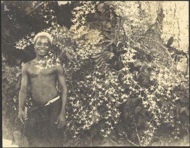 Polian standing beside an orchid, Government House, Rabaul, New Guinea, ca. 1929 / Sarah Chinnery