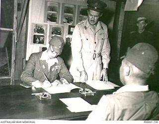 THE SOLOMON ISLANDS, 1945-09-08. LIEUTENANT GENERAL MASATANE KANDA, COMMANDER XVII ARMY, SIGNING THE INSTRUMENT OF SURRENDER AT II AUSTRALIAN CORPS HEADQUARTERS AT TOROKINA, BOUGAINVILLE ISLAND. ..
