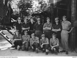 GREEN ISLAND, QLD. 1944-12-21. 109 BRIGADE ORDNANCE FIELD PARK NCOS AND MEN AT THE FRONT OF TECHNICAL STORES LORRIES. CAPTAIN S G DEWAR, OFFICER COMMANDING, (12), STANDS AT THE EXTREME FRONT RANK. ..