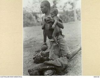 MENDAROPU, NEW GUINEA, 1942-10. A NATIVE MOTHER FROM AN OUTLYING VILLAGE OFFERING COCONUTS FOR SALE TO TROOPS OF THE 128TH REGIMENT, 32ND UNITED STATES DIVISION