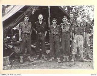 WEWAK AREA, NEW GUINEA, 1945-06-28. CAPT A.J. MOONEY, REGIMENTAL MEDICAL OFFICER (2) WITH MEMBERS OF THE REGIMENTAL AID POST OUTSIDE THE REGIMENTAL AID POST TENT AT BATTALION HEADQUARTERS, 2/8 ..