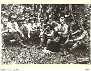 DUMPU, NEW GUINEA, 1943-10-08. MEMBERS OF NO. 3 SECTION, 2/6TH AUSTRALIAN FIELD COMPANY, ROYAL AUSTRALIAN ENGINEERS, ENJOYING A DRINK OF FRUIT JUICE DURING A REST PERIOD, SHOWN ARE:- SAPPER A. ..