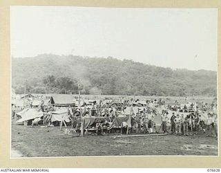 LAE, NEW GUINEA. 1944-10-27. PERSONNEL OF B COMPANY, 14/32ND INFANTRY BATTALION WITH THEIR IMPROVISED SHELTERS WHICH THEY ARE USING SINCE PACKING UP THEIR GEAR FOR EMBARKATION