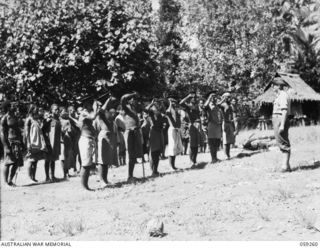 ULUGUDU, NEW GUINEA, 1943-10-23. VILLAGE OFFICIALS SALUTING NX155085 CAPTAIN R.G. ORMSBY OF THE AUSTRALIAN AND NEW GUINEA ADMINISTRATIVE UNIT