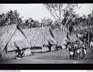BISIATABU, SOGERI VALLEY, NEW GUINEA. 1943-07-01. NATIVE PERSONNEL OF THE 1ST PAPUAN INFANTRY BATTALION RETURNING TO CAMP AFTER A RIFLE SHOOT ARE FROM MILNE BAY AREA. LIVING QUARTERS OF NATIVE ..