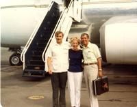 Three people posing in front of a plane