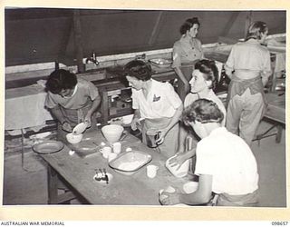 LAE, NEW GUINEA. 1945-11-08. CORPORAL E. NELSON (1); LANCE CORPORAL HUMBERG, INSTRUCTOR (2); SERGEANT D. SANDERSON (3); AND SERGEANT M. STORNOSS (4) PREPARING A SPONGE SANDWICH AND MADIERA CAKE, ..