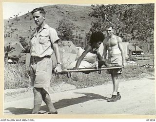 1942-12-18. NEW GUINEA. A CARRIER CARRIED. THIS NATIVE BOY INJURED IN AN ARGUMENT WITH ANOTHER NATIVE WAS CARRIED FROM AN RAAF BOMBER WHICH HAD FLOWN HIM TO AN RAAF MEDICAL RECEIVED STATION. NATIVE ..