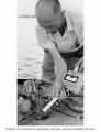 Kelshaw Bonham taking radiation readings from a crab aboard ship, Bikini Atoll, summer 1964