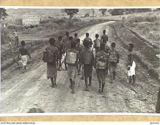 DUMPU, NEW GUINEA. 1943-12-06. A TEAM OF NATIVE BOYS EMPLOYED BY THE 18TH AUSTRALIAN ANTI-MALARIAL CONTROL UNIT SETTING OUT FOR THEIR DAYS WORK SPRAYING ALL MOSQUITO BREEDING PLACES WITH A SPECIAL ..