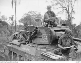BOUGAINVILLE. 1945-05-23. A TANK CREW OF B SQUADRON, 2/4 ARMOURED REGIMENT, READING THE MAIL DURING THE MOVE FORWARD IN SUPPORT OF 58/59 INFANTRY BATTALION'S ADVANCE ALONG THE BUIN ROAD SOUTH OF ..