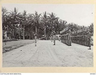 TOL PLANTATION, WIDE BAY, NEW BRITAIN. 1945-07-02. HIS ROYAL HIGHNESS, THE DUKE OF GLOUCESTER, GOVERNOR-GENERAL OF AUSTRALIA (1), TAKING THE SALUTE AT A GUARD OF HONOUR AT TOL BEACHHEAD PRIOR TO ..