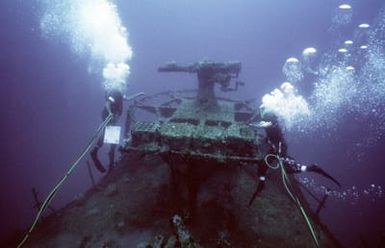 Navy divers from Moible Diving Salvage Unit One measure the remains of a deck gun on the sunken World War II Japanese merchant ship KIZUGAWA MARU during Project Sea Mark, a four year undersea survey and mapping study of naval historic sites. The study is being conducted in conjunction with the U.S. Park Service's Submerged Cultrual Resource Unit