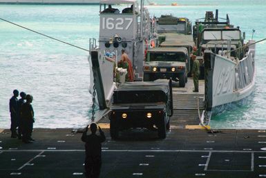 A US Navy (USN) Sailor guides a US Marine Corps (USMC) 31st Marine Expeditionary Unit (MEU) vehicles from a LCU 1600 Class Utility Landing Craft (LCU 1627) into the well deck of the Harpers Ferry Class Dock Landing Ship, USS HARPERS FERRY (LSD 49) in preparation for scheduled Spring Patrol deployment