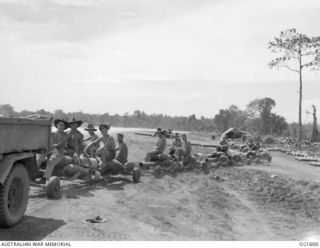 TADJI NEAR AITAPE, NORTH EAST NEW GUINEA. C. 1944-10. BOMBS BEING HAULED ON TRAILERS BEHIND A TRUCK FOR LOADING ONTO BEAUFORT BOMBER AIRCRAFT OF NO. 8 SQUADRON RAAF. ONE BEAUFORT SQUADRON HOLDS THE ..