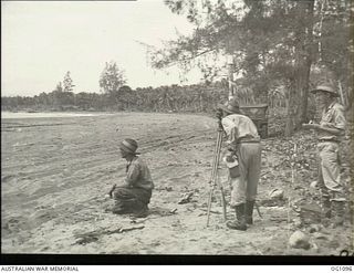 AITAPE, NORTH EAST NEW GUINEA. C. 1944-06. CORPORAL H. J. CLARKE, FOOTSCRAY, VIC, FLIGHT LIEUTENANT G. J. MCGUIRE, FORMER MAYOR OF ROCKDALE, NSW, NOW RAAF SURVEYOR (LOOKING THROUGH THEODOLITE), AND ..