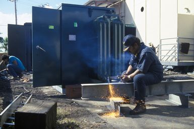 Local contractors work to get a US supplied generator on-line. The generator and other hardware were flown to Pago Pago by a 22nd Military Airlift Command C-5 Galaxy aircraft