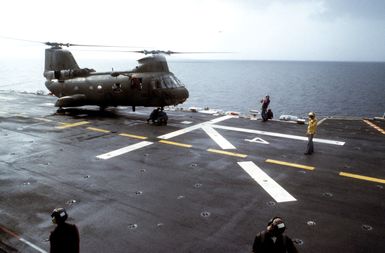 A CH-46 Sea Knight helicopter on the flight deck of the amphibious assault ship USS GUAM (LPH 9) during the multi-service, multinational Operation URGENT FURY