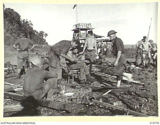 1943-09-22. NEW GUINEA. AUSTRALIAN TROOPS CAPTURE LAE. AN AUSTRALIAN FLAG FLYING FROM A JAPANESE OBSERVATION TOWER INSIDE LAE