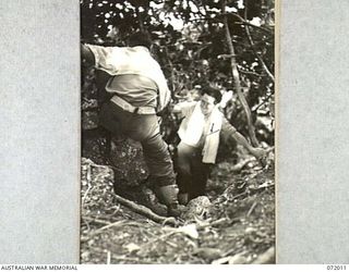 KILIGIA, PAPUA, NEW GUINEA. 1944-04-03. QX59621 SIGNALMAN J.J. BARRON (1), OF THE 5TH DIVISION, CLIMBING A PATH ON A CLIFF FACE AFTER A SWIM AT THE TINY BEACH ALONGSIDE HEADQUARTERS 5TH DIVISION
