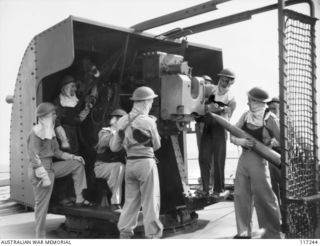 NAURU ISLAND. 1945-09-13. MEMBERS OF THE GUN CREW ABOARD THE ROYAL AUSTRALIAN NAVY VESSEL HMAS DIAMANTINA AT THE READY AS THE VESSEL APPROACHES THE ISLAND, IN CASE OF ANY TREACHERY ON THE PART OF ..