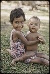 Young girl holding an infant, girl is smiling