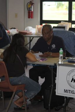 SAIPAN, August 13, 2015 - A FEMA mitigation Specialist provides a Typhoon Soudelor survivor with information about resilient rebuilding. Photo by Ron Roth.