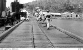 PHYSICAL DRILL ON THE WHARF AT PORT MORESBY. THE TROOPS WERE KEPT FIT BY PLENTY OF THIS SORT OF THING DURING THE COOLER HOURS OF THE DAY. (DONATED BY LIEUTENANT COMMANDER G.A. HILL, RNR.)