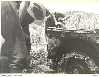 KESAWAI, RAMU VALLEY, NEW GUINEA, 1944-03-05. MEMBERS OF THE 2/12TH INFANTRY BATTALION ATTEMPTING TO MOVE A JEEP BOGGED IN THICK MUD NEAR KESAWAI. THE SLIGHTEST RAIN MAKES THESE TRACKS USELESS FOR ..