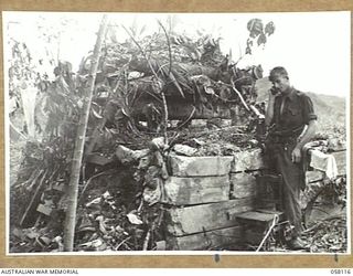 FINSCHHAFEN, NEW GUINEA, 1943-10-02. ENEMY EQUIPMENT WAS SOON PUT TO USE BY OUR TROOPS. NX21500 SIGNALLER O.L. PURCELL OF THE 9TH AUSTRALIAN DIVISION IS USING A JAPANESE TELEPHONE FROM ONE OF THE ..