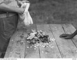 HOPOI, NEW GUINEA, 1943-10-30. JAPANESE INVASION MONEY HANDED IN TO NX155085 CAPTAIN R.G. ORMSBY OF THE AUSTRALIAN AND NEW GUINEA ADMINISTRATIVE UNIT BY THE NATIVES OF THE AREA, BEING BURNED TO ..