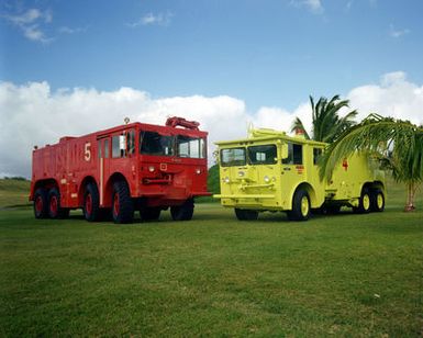 A left front view of a new lime-colored fire engine used at the base. On the left is the old-style fire engine