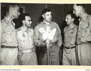 PORT MORESBY, PAPUA, 1944-02-26. THE GENERAL MANAGER, AUSTRALIAN BROADCASTING COMMISSION, LIEUTENANT COLONEL C.J.A. MOSES (3), WITH MEMBERS OF THE STAFF OF "9PA", THE AUSTRALIAN BROADCASTING ..